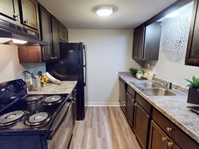 Little Rock apartment for rent - A kitchen with a black stove top oven and black refrigerator.