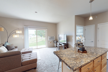 Williston apartment for rent - A living room with a couch, chair, and a table with a clock on it.