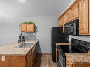 Topeka apartment for rent - a kitchen with black appliances and granite counter tops