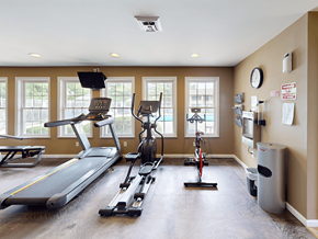 Valley Park apartment for rent - A spacious gym with a treadmill, elliptical trainer, and stationary bike.