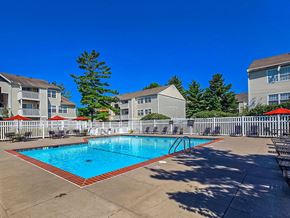 Florissant apartment for rent - A swimming pool surrounded by a white fence and apartment buildings.