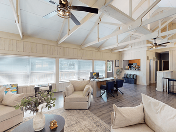 Fenton apartment for rent - A living room with a ceiling fan and a table with a vase of flowers on it.