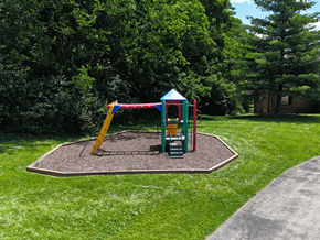 Fenton apartment for rent - A playground with a yellow slide and a green and red playhouse.