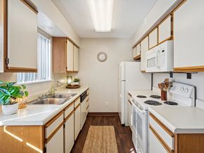 Cedar Rapids townhouse for rent - a kitchen with white appliances and wooden cabinets