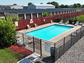 Waite Park apartment for rent - A pool surrounded by a black fence with a sign on it.