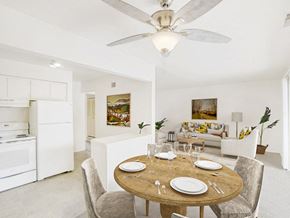 East Lansing townhouse for rent - a dining area with a wooden table and chairs and a kitchen in the background