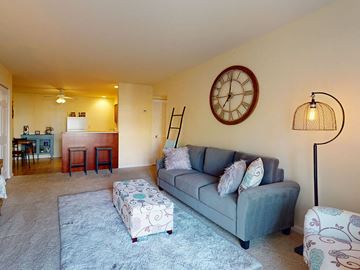 Affton apartment for rent - a living room with a couch and a clock on the wall