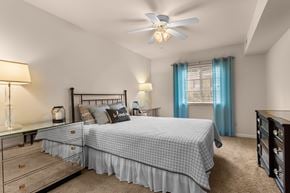 Affton apartment for rent - A bedroom with a bed, dresser, and ceiling fan.