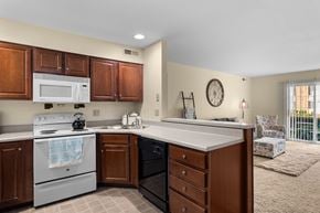 Affton apartment for rent - A kitchen with a white stove top oven and a white microwave above it.