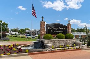 Affton apartment for rent - A sign for Heritage Estates Apartments is in front of a brick building.