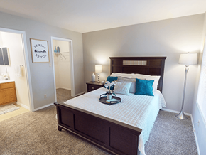 Oakville apartment for rent - A bedroom with a large bed and a carpeted floor.