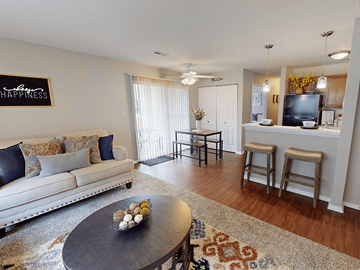 Oakville apartment for rent - A living room with a white couch and a coffee table with a bowl of fruit on it.