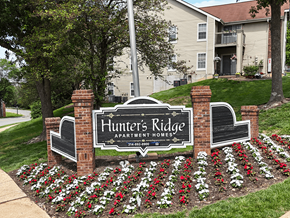 Oakville apartment for rent - A sign for Hunter's Ridge Apartment Homes is surrounded by flowers.