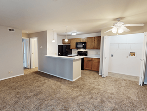 Oakville apartment for rent - A kitchen with a white counter and a black fridge.