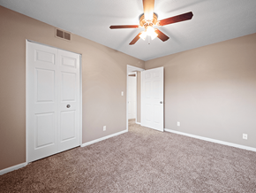Clarksville apartment for rent - an empty bedroom with a ceiling fan and doors