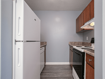 Wichita apartment for rent - an empty kitchen with a white refrigerator and stove
