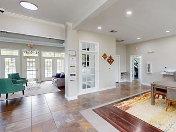 Denham Springs apartment for rent - A living room with a green chair and a brown rug.