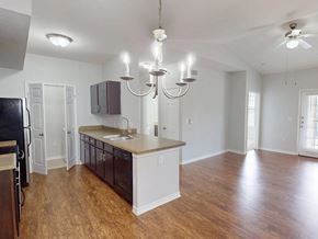 Denham Springs apartment for rent - A kitchen with a black refrigerator and wooden floors.