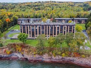 Duluth apartment for rent - A large building sits on a cliff overlooking a body of water.