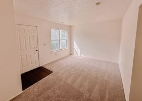 Columbus townhouse for rent - an empty living room with a white door and carpet