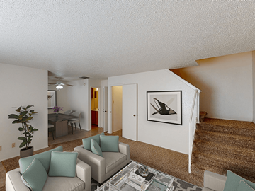 Lubbock apartment for rent - a living room with a couch and a chair and a staircase