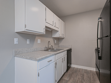 Wichita apartment for rent - an empty kitchen with white cabinets and stainless steel appliances