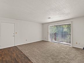 Lenexa apartment for rent - an empty living room with a door to a patio