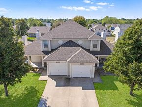 Topeka townhouse for rent - a house with a garage and a yard with trees