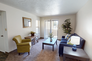 Albuquerque apartment for rent - A living room with a yellow chair, a blue couch, and a coffee table.