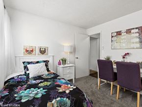 Fairborn apartment for rent - a bedroom with a bed and a desk with two chairs