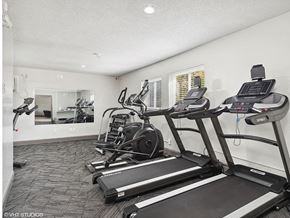 Fairborn apartment for rent - the gym in the home has cardio equipment and a large mirror