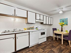 Fairborn apartment for rent - a kitchen with white cabinets and a dining room table