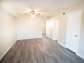 Mcpherson apartment for rent - A room with a ceiling fan and wood flooring.