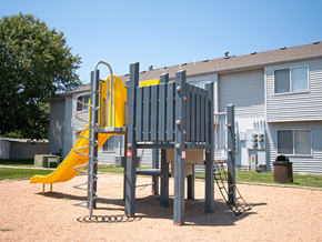 Mcpherson apartment for rent - A playground with a yellow slide and a grey play structure.