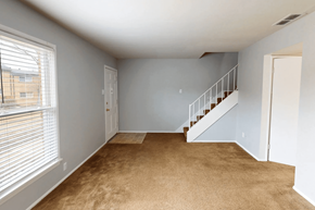 St. Louis apartment for rent - A room with a carpeted floor and a staircase.