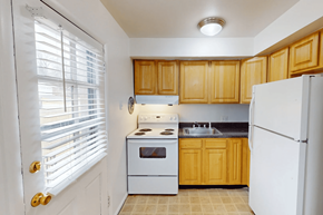 St. Louis apartment for rent - A kitchen with wooden cabinets and white appliances.