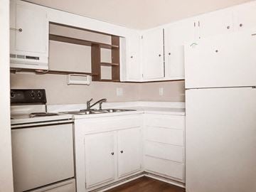 Terre Haute apartment for rent - a kitchen with white cabinets and a sink and a refrigerator
