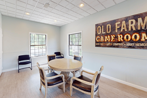 Grand Rapids townhouse for rent - A room with a table and chairs and a sign that says Old Farm Game Room.