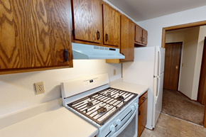Grand Rapids townhouse for rent - A kitchen with a white stove top oven and wooden cabinets.