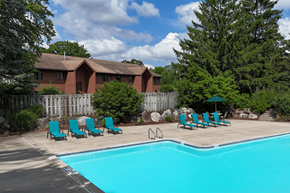 Grand Rapids townhouse for rent - A pool with chairs and a house in the background.