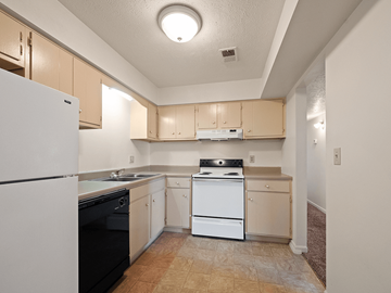 Clarksville apartment for rent - A kitchen with a white refrigerator and black dishwasher.