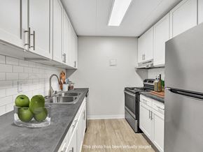 Rochester apartment for rent - a white kitchen with stainless steel appliances and white cabinets
