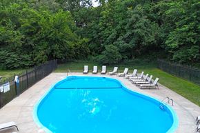 Omaha apartment for rent - A pool surrounded by trees and chairs.