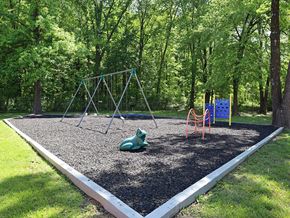 Louisville apartment for rent - A playground with a swing set and a slide.