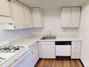 Florissant townhouse for rent - A kitchen with white cabinets and a white stove.