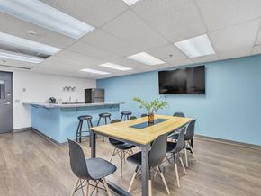 Saint Cloud apartment for rent - a conference room with a table and chairs with a kitchenette in the background