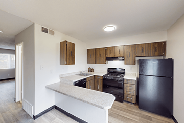 Florissant townhouse for rent - A kitchen with black appliances and wooden cabinets.