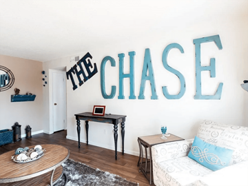 Florissant townhouse for rent - a living room with a couch and a wall spelling out the chase