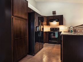 Valley Center triplex for rent - a kitchen with black appliances and wooden cabinets