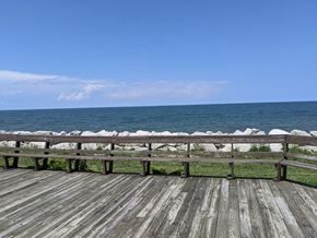 Sandusky apartment for rent - A wooden deck overlooks a body of water.